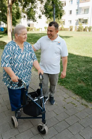 Begleiteter Spaziergang mit Rollator durch eine Pflegekraft von Bavaria Vitalpflegedienst — wir versorgen Feldmoching-Hasenbergl in München