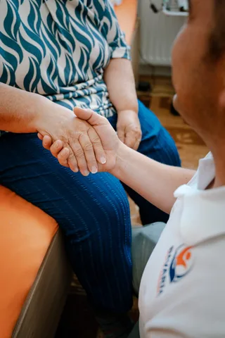 Nahaufnahme: Handschlag zwischen einer Pflegekraft von Bavaria Vitalpflegedienst und einer Patientin — wir versorgen Schwabing-West in München